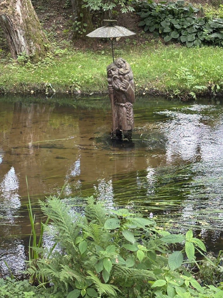Skulptūra su skėčiu tvenkinio viduryje