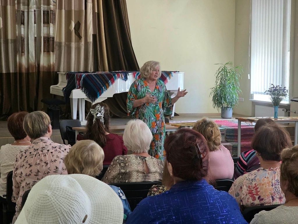 Pilna salė žiūrovų klausosi viešnios Daugų bendruomenės salėje