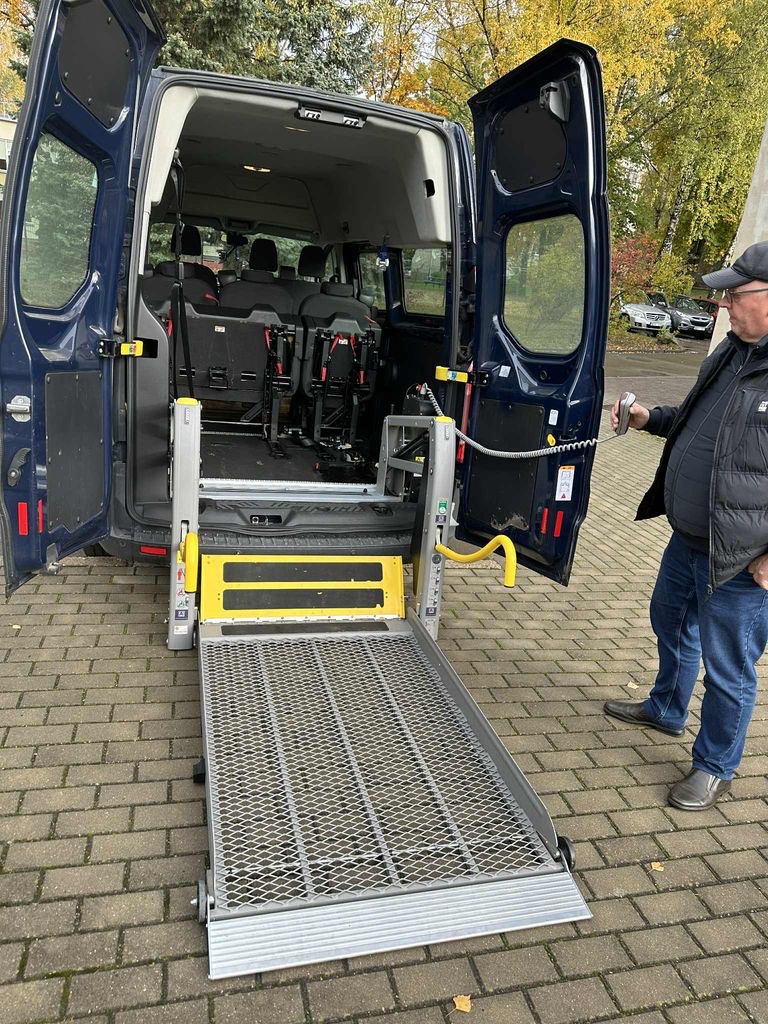 Nuleista mikroautobuso rampa ir šalia stovintis vairuotojas